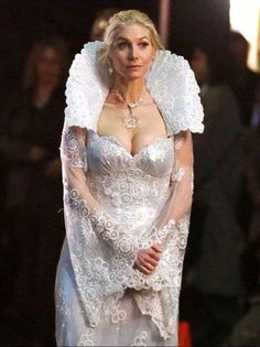 a woman in a white dress and veil on the runway