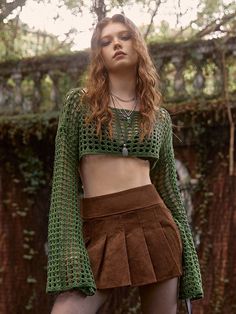 a woman in a green top and brown skirt