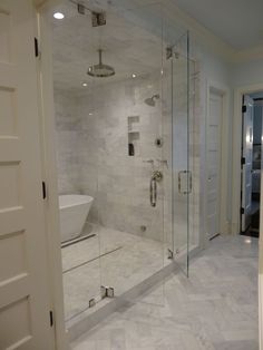 a bathroom with a walk in shower next to a bathtub and toilet bowl on the wall