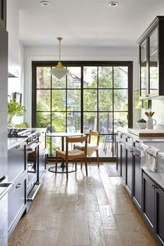 a kitchen with wooden floors and black cabinets