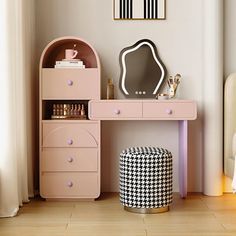 a pink desk with drawers and a mirror on it next to a white bed in a room