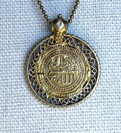 Ornate Filigree pendant features Arabic on metal ball chain... Nickel Free Brass Medallion Necklace With Round Pendant, Nickel-free Brass Medallion Necklace With Round Pendant, Bronze Filigree Pendant Necklace, Silver Medallion Pendant Necklace In Brass, Silver Brass Medallion Pendant Necklace, Spiritual Silver Medallion Necklace In Brass, Nickel-free Silver Medallion Necklace In Brass, Brass Charm Necklace With Large Round Pendant, Vintage Gold Ball Chain Jewelry