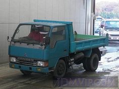 a blue truck parked in front of a building