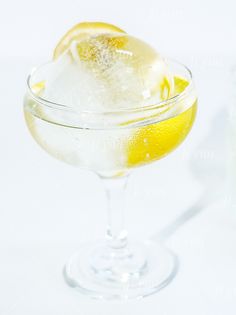 a glass filled with ice and lemon on top of a table