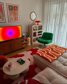 a living room filled with furniture and a flat screen tv on top of a wooden stand