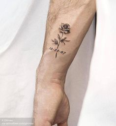 a person's arm with a rose tattoo on it and the word love written in cursive writing