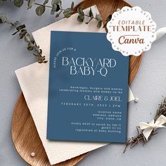 a baby - 0 announcement card with eucalyptus leaves on it next to an envelope and flowers