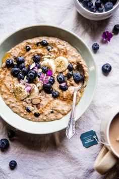 a bowl of oatmeal with blueberries and banana slices on the side