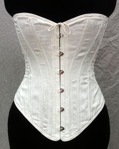 "This style corset eternally stylish, yet for the 1905 period enhances the signature s-curve shape of the era. It has a lower bust line, encourages the torso to tip forward, and has ¼\" spiral bones on the curved seams. The Mae exhibits the Art Nouveau style with its graceful curves. For the convenience of donning the corset by yourself, we have included a center front opening busk closure. Also available with no busk opening: https://www.etsy.com/listing/481708045/edwardian-corset-s-bend Availa Historical Underbust Corset Dress For Wedding, Victorian Underbust Wedding Bodice, Wedding Underbust Corset Dress With Historical Design, Formal Fitted Corset Dress With Boning, Elegant Underbust Bodice For Costume, Historical Underbust Corset With Fitted Bodice, Victorian Corset With Boning, Victorian Corset With Boned Bodice, Victorian Corset With Historical Design