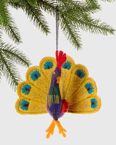 a peacock ornament hanging from a christmas tree