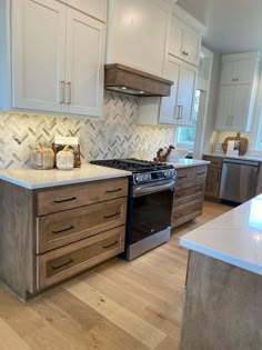 a kitchen with white cabinets and wood floors