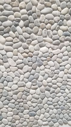 a white and grey stone wall with rocks on it