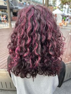 Cool Hair Color For Curly Hair, Curly Skunk Highlights, Peak A Boo Highlights Curly Hair, Magenta Highlights Curly Hair, Purple Highlights In Brown Hair Curly, Purple Peekaboo Highlights Curly Hair, Brown Hair Pink Highlights Curly, Curly Draculaura Hair, Brown Curly Hair With Purple Highlights