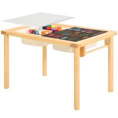 a child's drawing table with chalk and crayons on the top in front of it