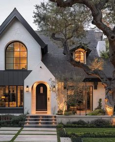 a white house with lots of windows and steps leading up to the front door,