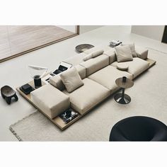 a living room with a large sectional couch and coffee table on the floor in front of it