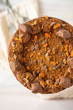 a close up of a cake with chocolate and oranges on the top, surrounded by other food items