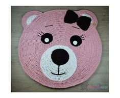 a crocheted pink bear rug with a bow on it's head and eyes