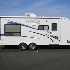 a white and blue motor home parked in a parking lot