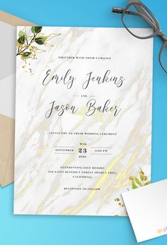 an elegant marble wedding card with gold foil and greenery on the front is surrounded by eyeglasses