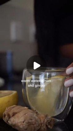 a woman mixing ingredients in a glass bowl with a banana and ginger next to it