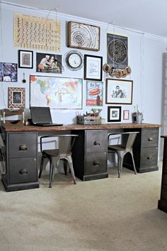 a desk with two chairs and pictures on the wall