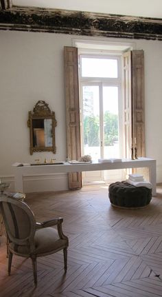 a room with a table, chair and mirror in it's centerpieces