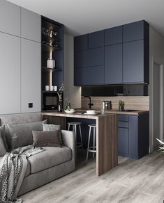 a living room and kitchen area with blue cabinets, grey couches and wooden flooring