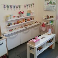 a room filled with lots of white shelves and counter top covered in candy bars, candies and other items