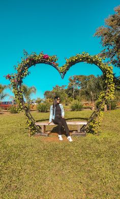 a person sitting on a bench with a heart shaped frame