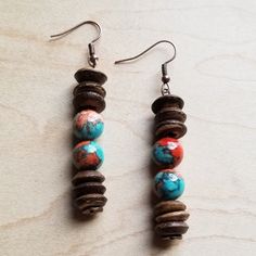 two brown and blue beads are hanging from earrings