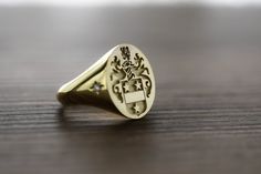 "gold diamond family crest signet ring delicately engraved with your family crest or any other initials or image you want ♡ the stones are cubic zirconia the ring has solid back. deep and detailed engraving very delicately handcrafted unisex - looks super cool on both women & men we offer real diamond option as the stone. for that, please send us a message ♡ there is an additonal cost of 12 usd for inside engravings. if you want any inside engravings please don't forget to add the \"Side or Mens Gold Signet Rings, Rings Signet, Family Crest Rings, Custom Signet Ring, Unisex Looks, Mens Pinky Ring, Rings Mens, Family Rings, Signet Ring Men