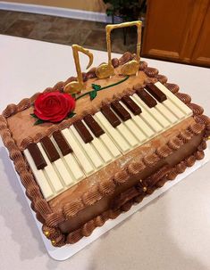 a sheet cake decorated with an organ keyboard and a rose on the top is sitting on a table