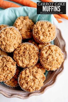 carrot cake muffins in a glass bowl on top of a blue napkin next to an orange carrot