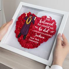 a person holding up a red heart shaped ornament with the words, his beloved he could so be dad and congratulationss to jack jackson new york university