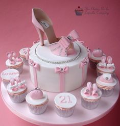 a cake that has some cupcakes on top of it with shoes and bags