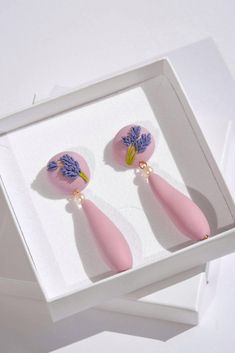 Blooming with style - introducing our new flower-inspired earrings. Lovingly crafted by hand, each earring is individually sculpted, inspired by the delicate and fragrant lavender flower. And as a finishing touch, the earrings are adorned with stunning freshwater pearls. ▫️ DETAILS ▫️ - Polymer clay in lavender purple shade.  - Hand-sculptured lavender flowers.  - Hand-sculptured beads (they are purposely not perfectly symmetric, as they have been crafted by hand and wanted to showcase their org Lavender Earrings, Lavender Flower, Purple Pearl, Earrings Elegant, Lavender Purple, Floral Jewellery, Lavender Flowers, Earrings Statement, Elegant Floral