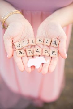 a woman's hands holding scrabble spelling out the word grace and an elephant