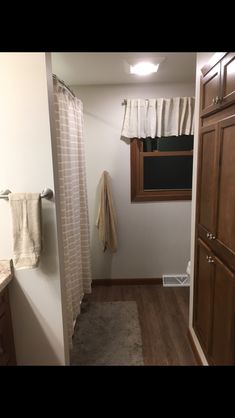 a bathroom with wooden cabinets and white walls