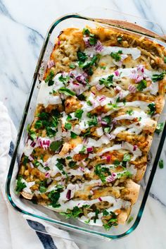 a casserole dish filled with chicken, onions, and cilantro sauce