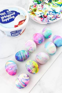 marbled easter eggs and yogurt are sitting on a countertop next to an ice cream container