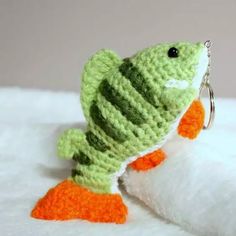 a crocheted keychain with a green and orange fish on it