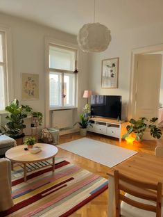 a living room filled with furniture and a flat screen tv on top of a wooden table