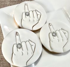 three decorated cookies with white frosting on top of each other in the shape of fingers