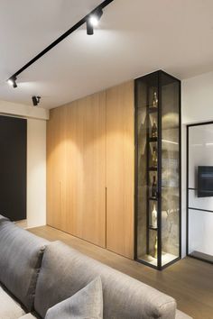 a living room with couches, cabinets and television on the wall in front of it