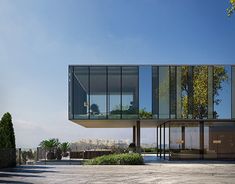 the building has glass walls and is surrounded by trees