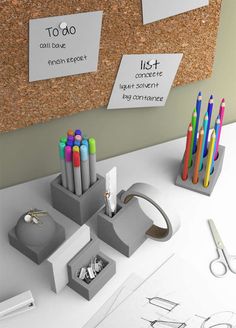 an office desk with pens, pencils and markers on the cork notice board next to it