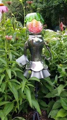 a garden statue in the middle of some plants