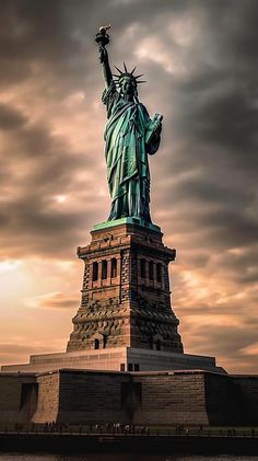 the statue of liberty is shown against a cloudy sky