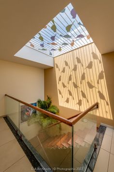 an indoor stair case with glass railing and skylight